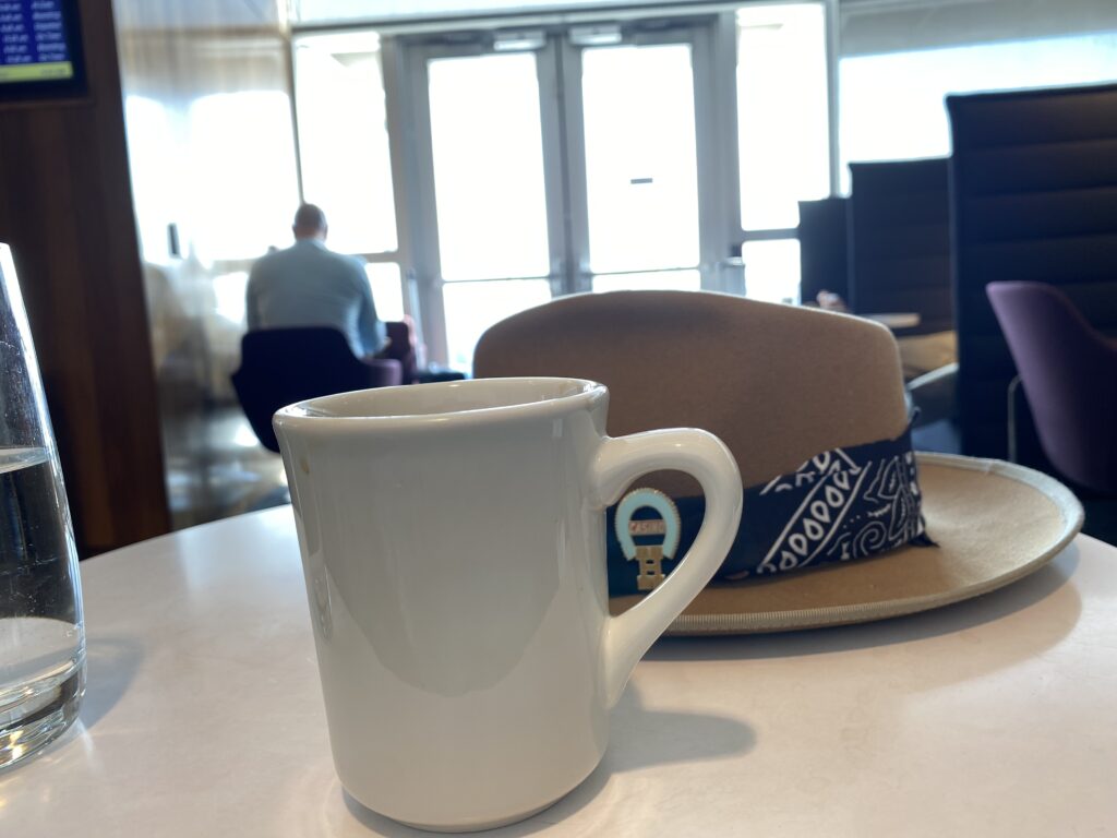 Coffee and hat on a white table.