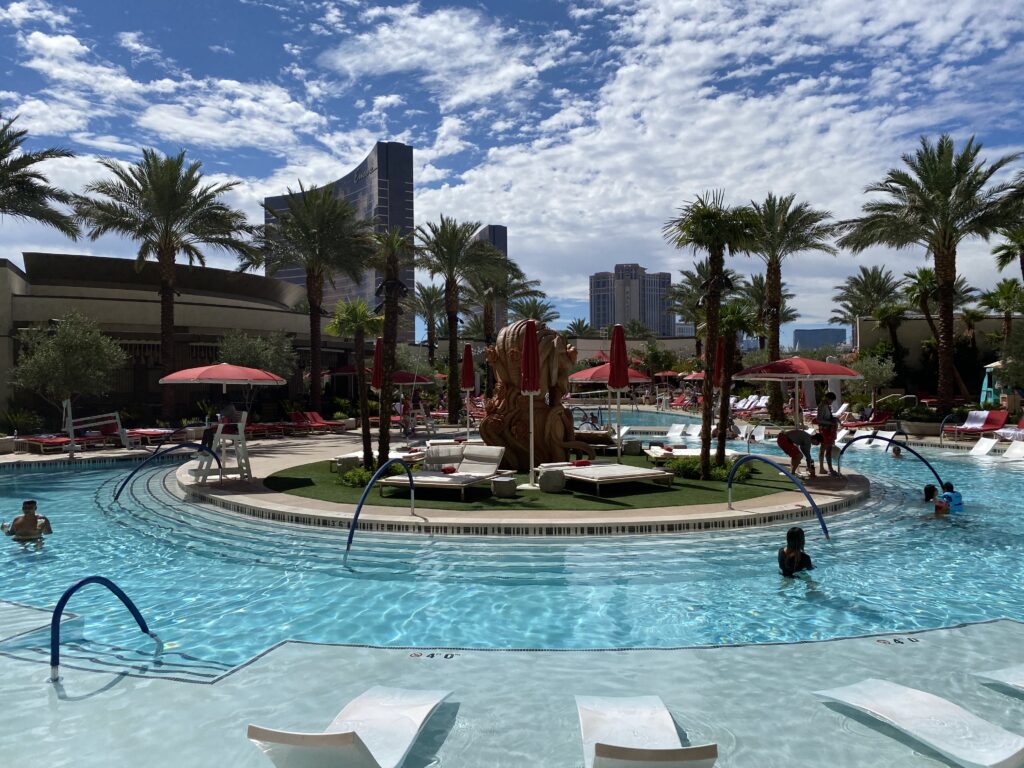 Pool with round, grass filled center surrounded by lounge chairs.