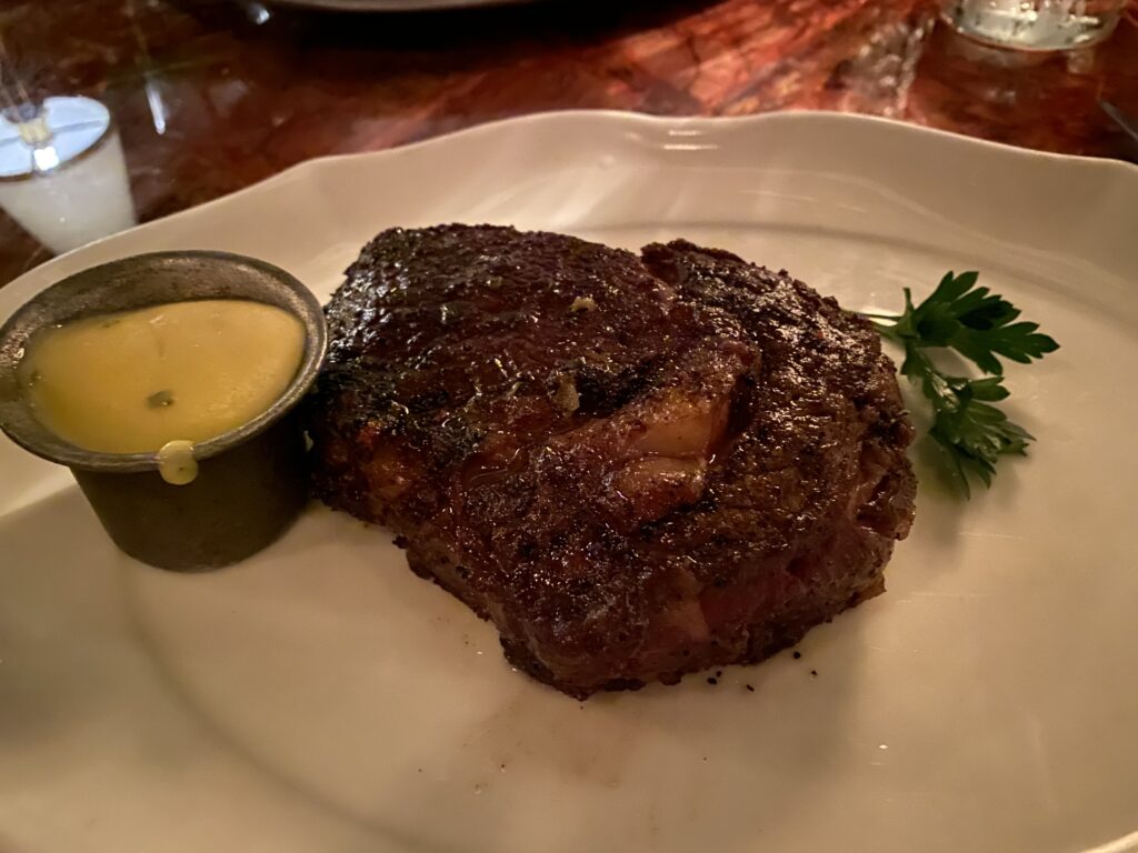 Ribeye steak on a white plate.