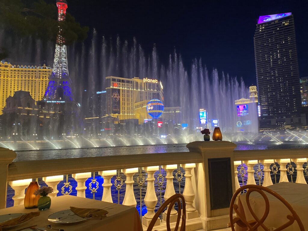 Fountains of Bellagio going off behind the railing at Picasso restaurant.