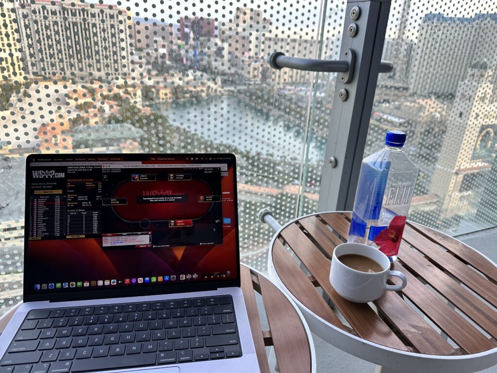 Computer, coffee, and water overlooking Bellagio fountains. 