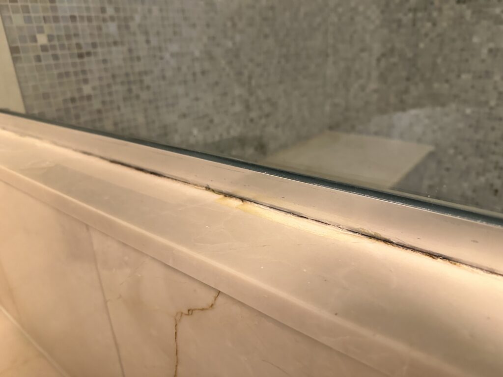 Cosmo bathroom door with dirty caulk lines. 